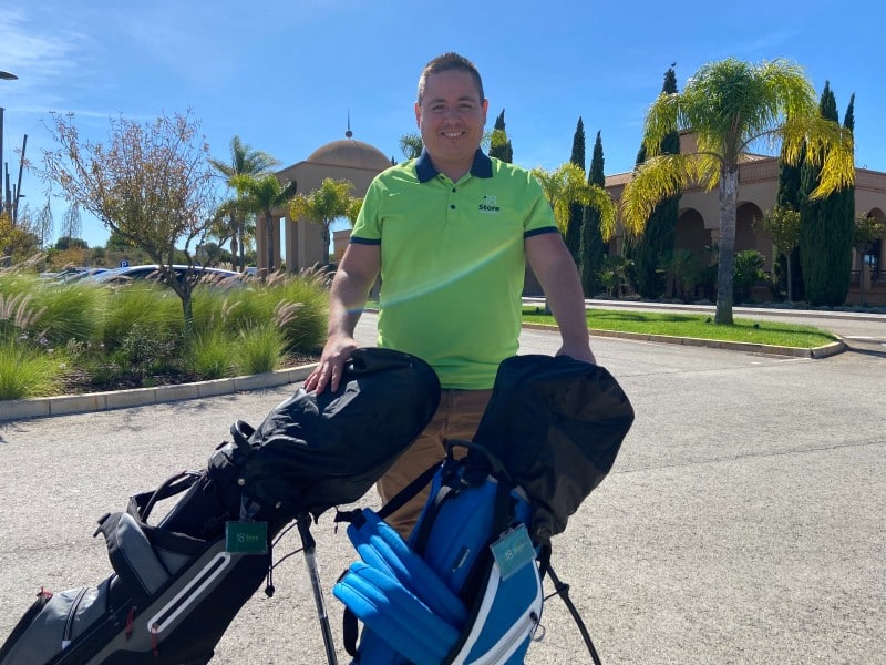 Ruben Martins with two 18Store rental golf bags outside a golf clubhouse